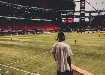 a person standing in a stadium watching a baseball game