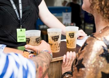 three filled Reuse Me cups on brown table