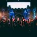 crowded people wearing LED bracelet raising hands in front of stage