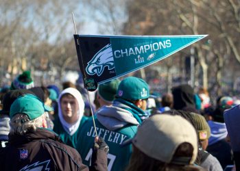 man holding Philadelphia Eagle pennant