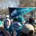 man holding Philadelphia Eagle pennant