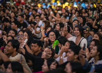 a large group of people taking pictures with their cell phones