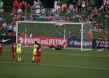group of person playing soccer on field