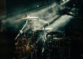a drum set up in front of a stage light