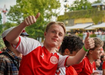 man in red and white nike crew neck t-shirt raising his hands
