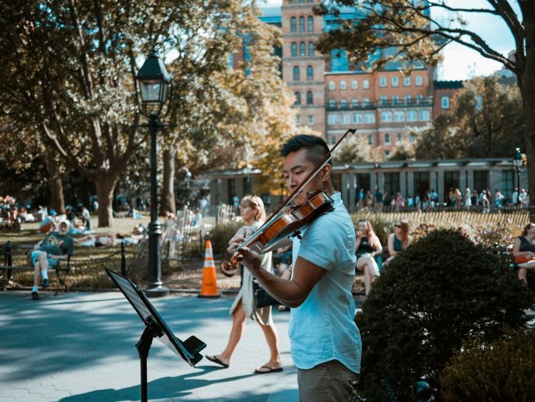 man playing violin at the park